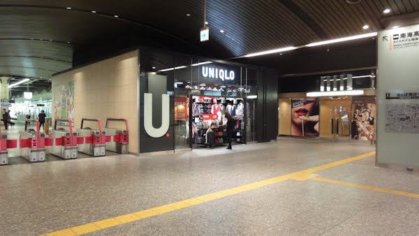 a small black store with uniqlo in white letters and a large letter U near the entrance